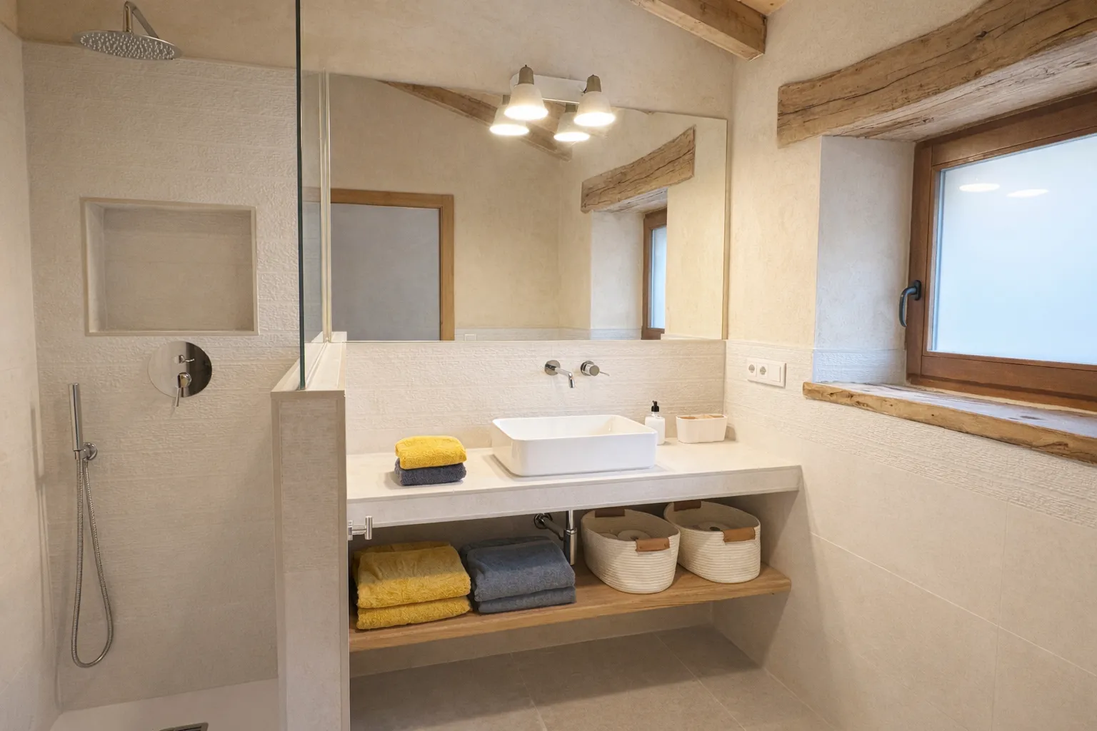 Baño en suite con acabados en piedra natural en Cumbres de Lores